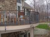 Custom design ironwork railing surrounding circular balcony with outdoor landscape in background.